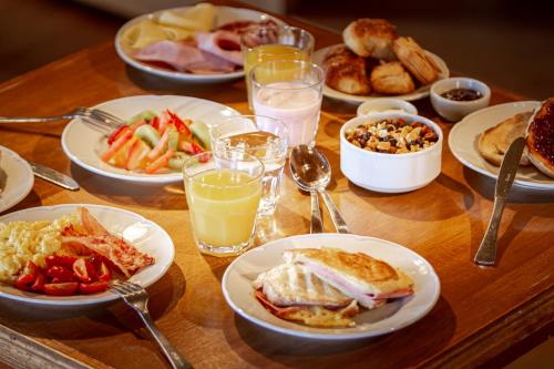 a wooden table with plates of food and drinks at Mirador del Lago Hotel in El Calafate