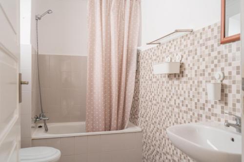 uma casa de banho com um lavatório, um WC e uma banheira em Amélia Apartment - Peniche Surf Camp em Peniche
