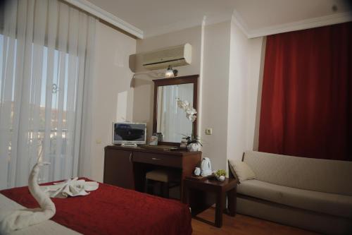 a hotel room with a bed and a desk and a television at STELLA HOTEL&Spa ALL INCLUSIVE in Kemer