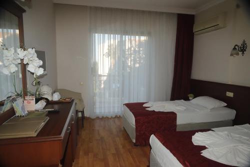 a hotel room with two beds and a desk at STELLA HOTEL&Spa ALL INCLUSIVE in Kemer