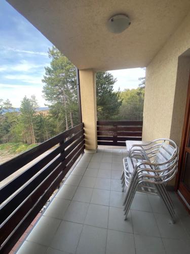 a balcony with two chairs and a large window at Apartman Jelen in Kaludjerske Bare