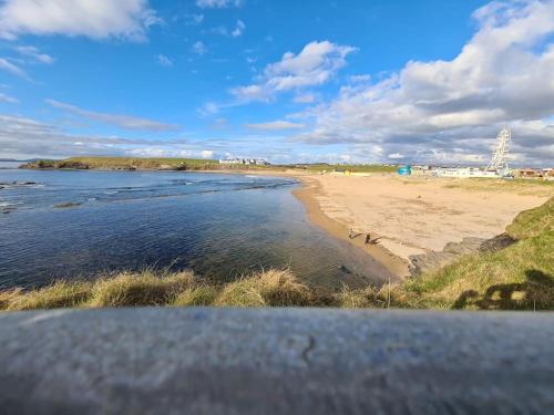 a view of a beach and the ocean on a cloudy day at Bundoran Seaside Stays House - WiFi, large spacious home in Bundoran
