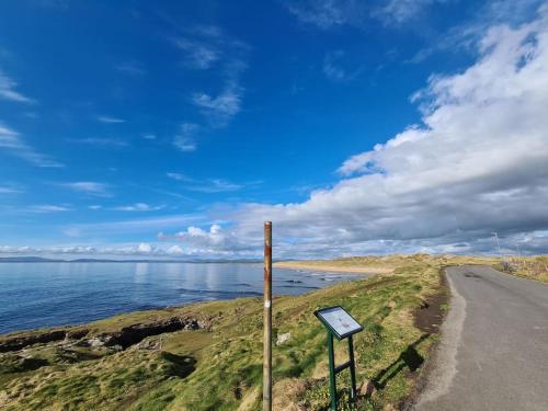 a sign on the side of a road near the water at Bundoran Seaside Stays House - WiFi, large spacious home in Bundoran