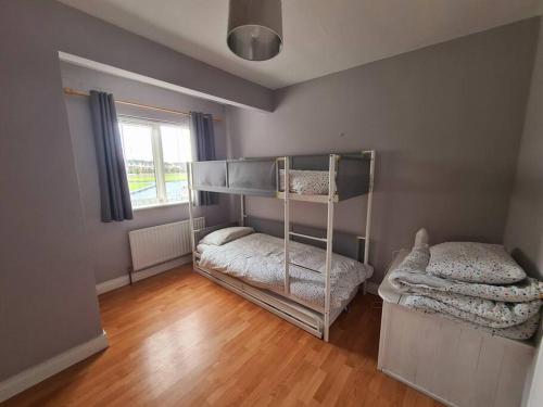 a bedroom with two bunk beds and a wooden floor at Bundoran Seaside Stays House - WiFi, large spacious home in Bundoran