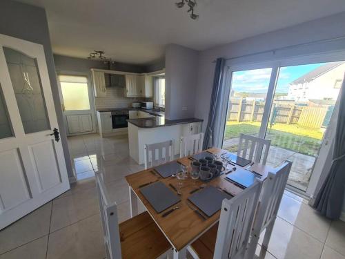 a kitchen and dining room with a table and chairs at Bundoran Seaside Stays House - WiFi, large spacious home in Bundoran