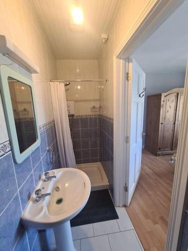 a bathroom with a sink and a shower at Bundoran Seaside Stays House - WiFi, large spacious home in Bundoran