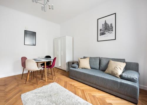 a living room with a couch and a table at Chmielna Warsaw City Centre Apartment in Warsaw