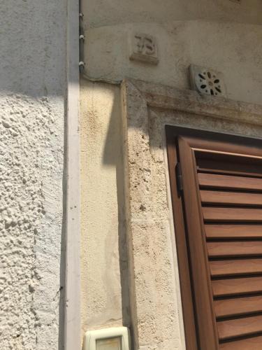 una porta per un edificio con una croce sopra di La dimora nel sottano alla strada a Polignano a Mare