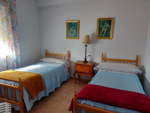 ein Schlafzimmer mit 2 Betten und einem Tisch mit einer Lampe in der Unterkunft Corazón de Aguilar in Aguilar de la Frontera