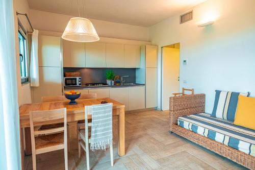 a kitchen and dining room with a wooden table at Tenuta Delle Ripalte in Capoliveri
