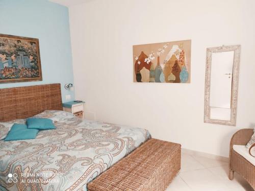 - une chambre avec un lit et un miroir dans l'établissement Bilocale con giardino posto auto splendida vista, à Montiano