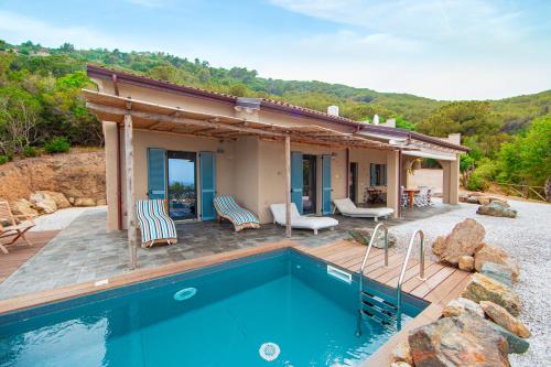 a house with a swimming pool and a house at Tenuta Delle Ripalte in Capoliveri