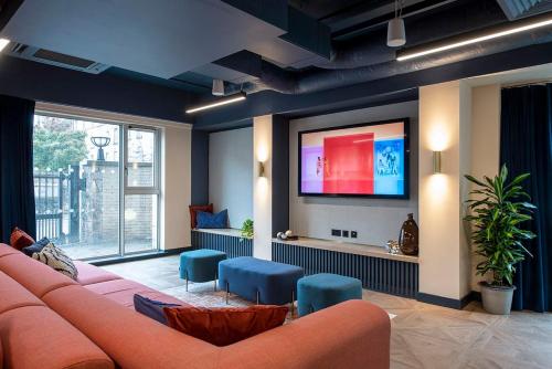 a living room with a couch and a flat screen tv at Silk Mill Edinburgh in Edinburgh