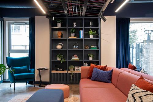 a living room with a couch and a shelf with plants at Silk Mill Edinburgh in Edinburgh