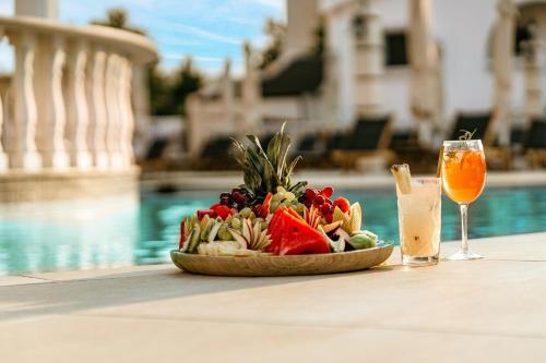 a plate of food on a table next to a pool at Wellness Santa Hotel - adults plus12 in Agia Triada
