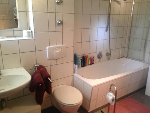 a bathroom with a toilet and a tub and a sink at Ferienwohnung Heil - Königs Wusterhausen in Königs Wusterhausen