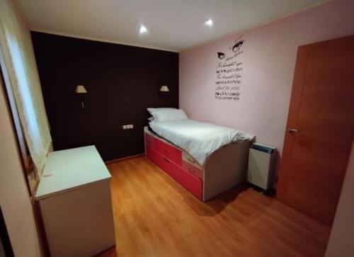 a small bedroom with a bed and a desk at Adosado al lado del Torreón in Benicàssim