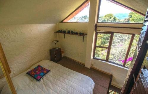 - une petite chambre avec un lit et 2 fenêtres dans l'établissement ex hacienda molino de pedreguera, à San Roque