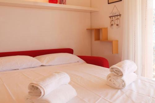ein weißes Bett mit Handtüchern auf dem Zimmer in der Unterkunft CASA MANU FINALE LIGURE in Finale Ligure