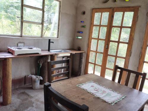 cocina con mesa de madera y algunas ventanas en ECO-LOFT, Sombra de Chañar,- Mallín Córdoba in 