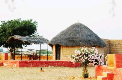 un pequeño edificio con techo de paja en AnanyaVaas en Dedha