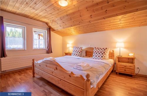 アローザにあるChalet Schwarzsee by Arosa Holidayのベッドルーム1室(大型木製ベッド1台付)