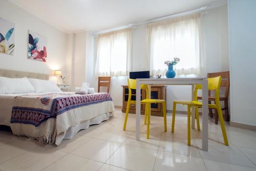 a bedroom with a bed and a table and chairs at Apartamentos AMAT - Only Adult - Playa El Bajondillo in Torremolinos