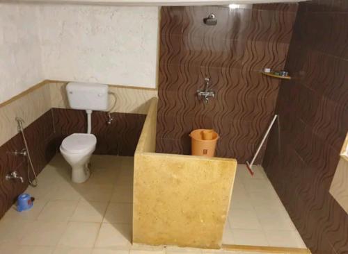 a small bathroom with a toilet and a shower at AnanyaVaas in Dedha