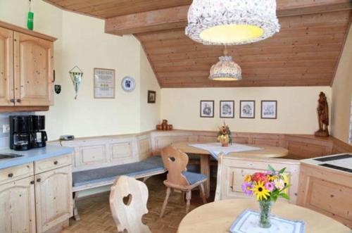 uma cozinha com mesa e cadeiras e uma mesa com flores em Haus Schuster em Kirchbach