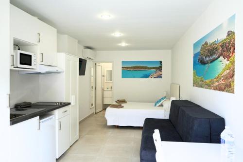- un salon avec un canapé et un lit dans une chambre dans l'établissement Apartamentos Vistalmar Mallorca, à Cala Figuera