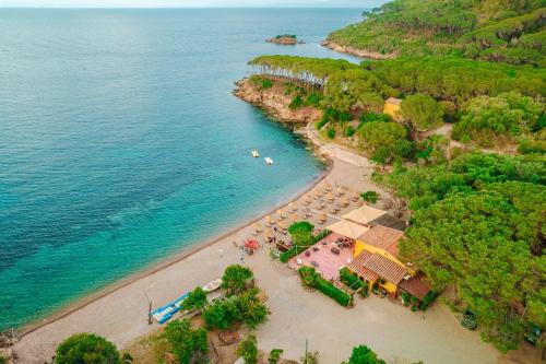 an aerial view of a beach with chairs and umbrellas at Tenuta Delle Ripalte in Capoliveri