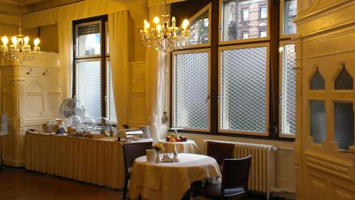a dining room with a table and some windows at Hotel Markgräfler Hof in Karlsruhe