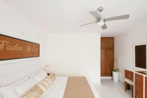a white bedroom with a bed and a ceiling fan at Saastah Hotel Boutique in Valladolid