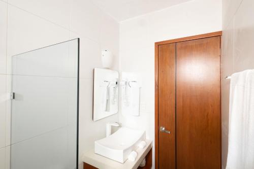 a white bathroom with a sink and a mirror at Saastah Hotel Boutique in Valladolid
