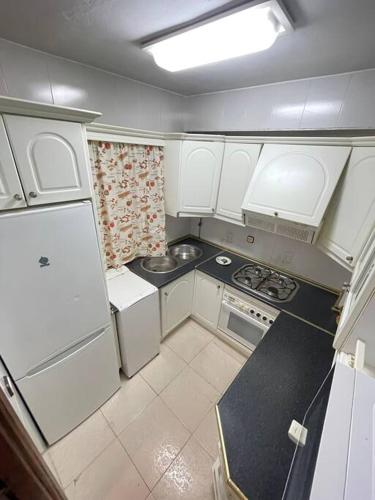 a small kitchen with white cabinets and appliances at Apartamento La Iglesia in Almodóvar del Río