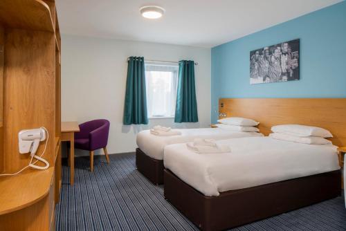 um quarto de hotel com duas camas e uma secretária em Bisham Abbey National Sports Centre em Marlow