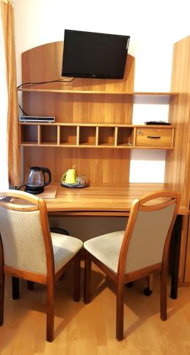 a wooden desk with two chairs and a television at Villa Hoffnung in Bad Elster