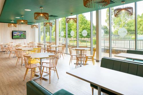 a restaurant with tables and chairs and windows at Bisham Abbey National Sports Centre in Marlow