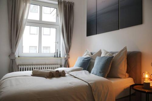 a bedroom with a large white bed with a window at Ferienwohnung Blaßdörfer - Traumhafte Altbauwohnung mit Self-Checkin und 93 qm2 in Bad Kissingen