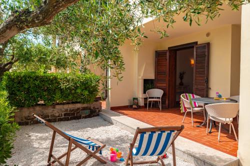 a patio with chairs and a table in a yard at Tenuta Delle Ripalte in Capoliveri