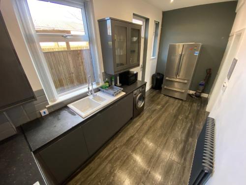 a kitchen with a sink and a refrigerator at Entire Holiday Home in Mirfield