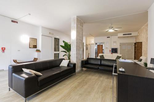 a living room with two black leather couches at Residence Das Nest in Riccione