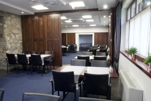 a waiting room with tables and chairs in a building at Hotel Patria Zakopane Centrum in Zakopane