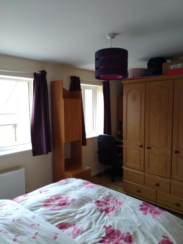 Schlafzimmer mit einem Bett, einer Kommode und Fenstern in der Unterkunft Felix in Harwell