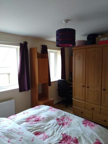 a bedroom with a bed and a dresser and windows at Felix in Harwell