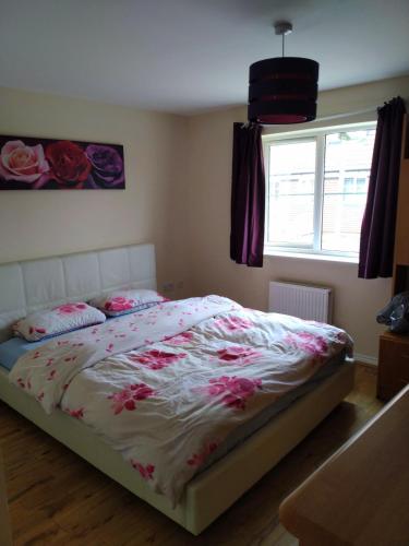 ein Schlafzimmer mit einem Bett mit rosa Blumen drauf in der Unterkunft Felix in Harwell
