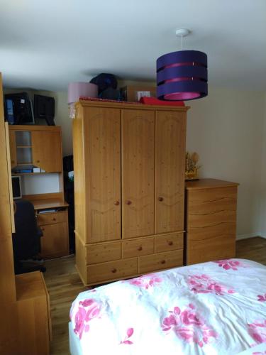 Schlafzimmer mit einem Bett und einem Holzschrank in der Unterkunft Felix in Harwell