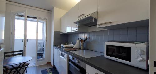 y cocina con encimera, microondas y mesa. en Frejus Plage T1 35m2, climatise, 2 personnes,, en Fréjus