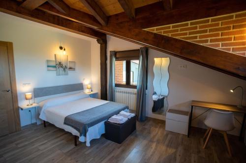 a bedroom with a bed and a desk in a room at La casita del abuelo in Galizano