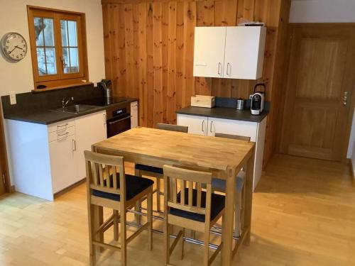 a kitchen with a wooden table and two chairs at BnB Försterlodge in Schwarzsee